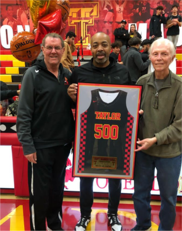 Coach Taylor is awarded a jersey in recognition of his 500th basketball win.